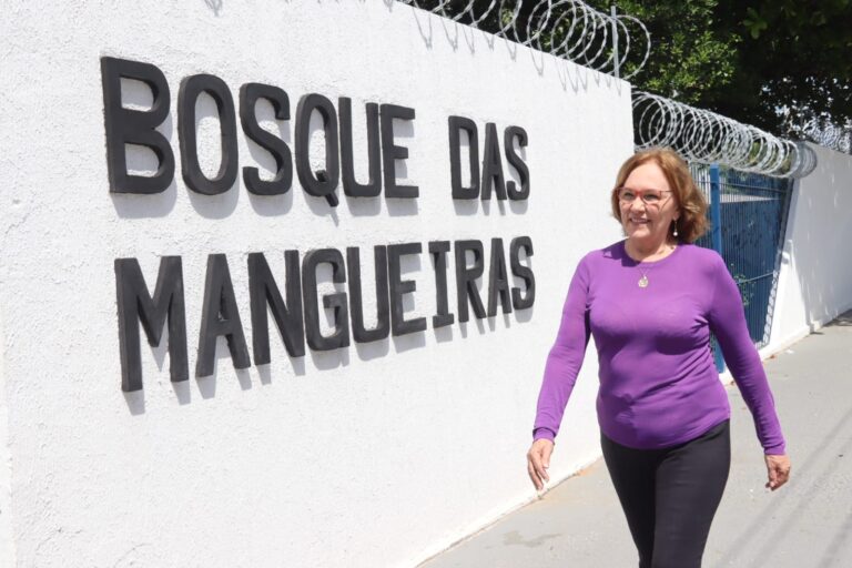 Senadora Zenaide caminhando na frente do letreiro do Bosque das Mangueiras.