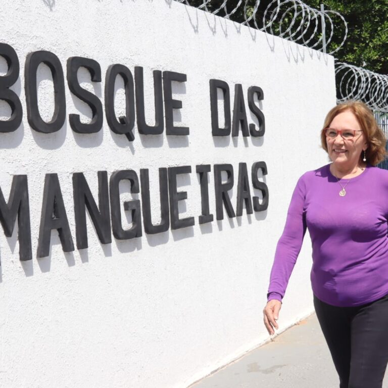 Senadora Zenaide caminhando na frente do letreiro do Bosque das Mangueiras.